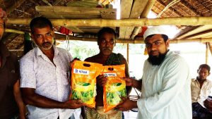 A farmer (center) receives seeds of BRRI dhan34 in Jessore District.